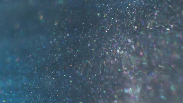 Glitter mix defocused. Glowing wave. Blue purple sparkling leak stream. Color bokeh particles floating abstract background reflection.