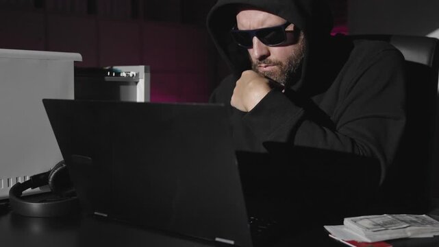 Cyber hacker attack creates security risk. Dark hacker breach exposes sensitive information. Office hacker typing code in secrecy. Online hacker crime threatens data safety.