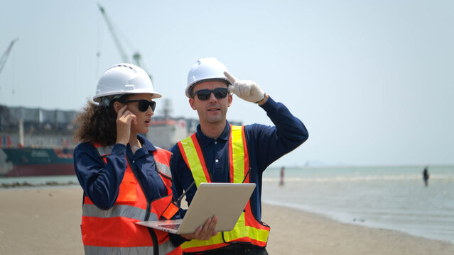 Engineers in safety gear walk beside the water at a port inspected the operations of the deep-sea port