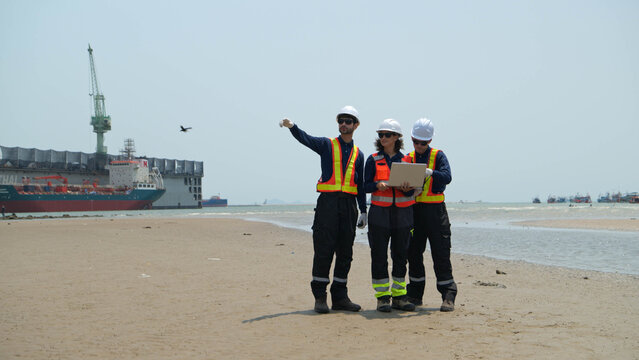 A team of engineers in safety gear walk beside the water at a port inspected the operations of the deep-sea port