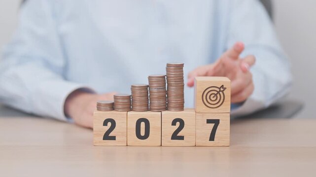 Happy New Year 2027 with Coins stack and dartboard icon. Strategy, goal, Money, Budget, tax, investment, financial, savings and New Year Resolution concepts