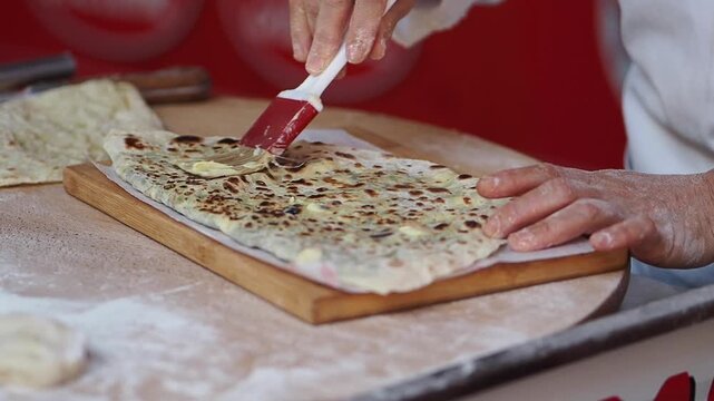 Making flatbread in a kitchen with a person preparing food on a wooden surface