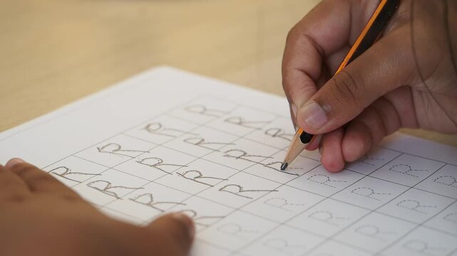 Child Practicing Handwriting by Tracing the Letter R