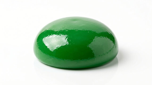 Green dome shaped object with a glossy finish rests flat on a plain transparent surface.