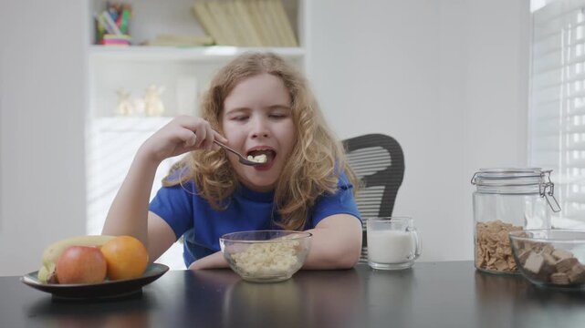 Child eating pasta at home. Child enjoying warm pasta meal. Child having healthy food indoors. Child sitting at table with pasta. Hungry kid eat paste for breakfast.