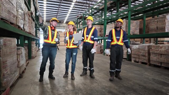 A team of industrial workers and engineers in safety gear inspect stored wood materials and warehouse inventory inside a large manufacturing facility.