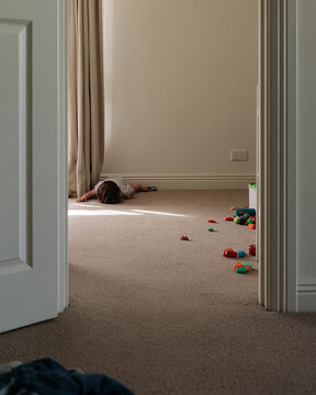 Child playing quietly in a sunlit room, toys scattered around, creating a cozy and warm atmosphere Generative AI