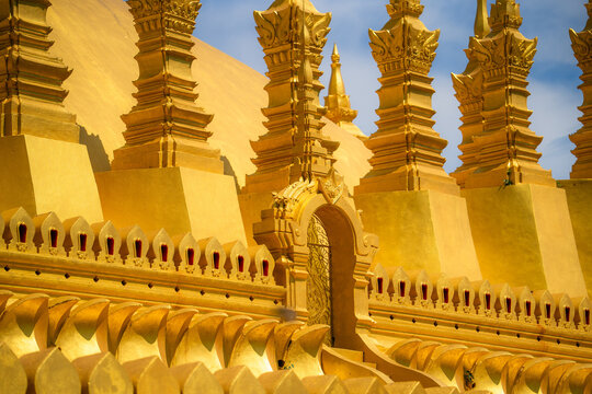 Golden buddhist temple architecture with ornate decorative details under blue sky