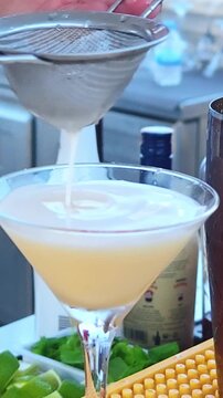 A bartender serves refreshing colorful drink at an outdoor beach bar. Bartender prepares and serves cocktails. Summer concept.