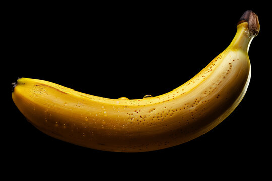 Single ripe banana with droplets isolated on black background with clipping path, concept of freshness and healthy nutrition