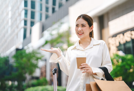 Single adult business asian woman confidence smiling holding coffee cup and shopping bag city people lifestyle