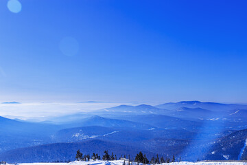 Obraz premium Aerial view of mountain ridges in soft fog. Beautiful white blue Peaks fades into distance. Minimal Nature abstract landscape, natural gradient color, environment winter serenity, panoramic skyline.