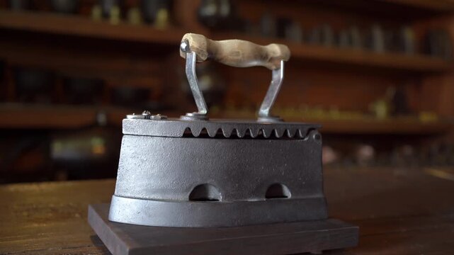 Antique charcoal cast iron with wooden handle on blurred background