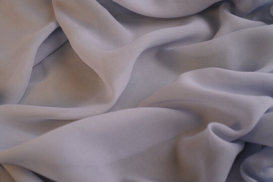 Top View Soft lavender fabric draped gently, folds catching light. Subtle sheen highlights texture, quiet elegance in every crease. Ideal for fashion, design, or textile presentations