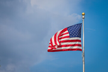 Obraz premium The United States of America flag waving in the wind on a sunny day