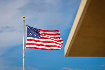 Obraz premium The United States of America flag waving in the wind on a sunny day