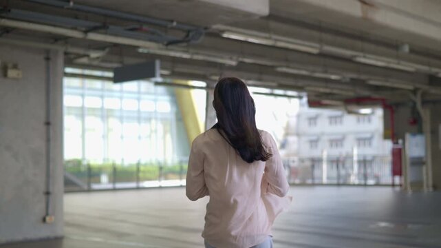 sad lonely teen girl standing on a bridge looking at blurred urban skyscrapers city buildings as a conceptual backdrop for youth mental health solitude city exploration lifestyle and modern commuter 