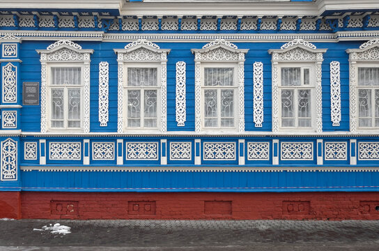 Blue Traditional Russian Wooden House With Ornate White Carved Window Frames And Folk Architecture Details
