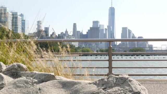 New York City Manhattan downtown financial district skyline, United States. Urban waterfront cityscape with skyscraper buildings, World Trade Center tower from Hudson River Park, riverfront promenade.