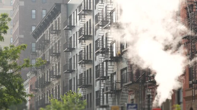 New York City urban residential buildings architecture, Manhattan classic street, United States of America. Typical red brick house, real estate property, USA. Fire escape metallic ladder. Hot steam.