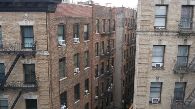 New York City urban residential buildings architecture, 125 street in Harlem, Manhattan, United States of America. Typical house in NYC, real estate property in USA. Fire escape metallic ladder.