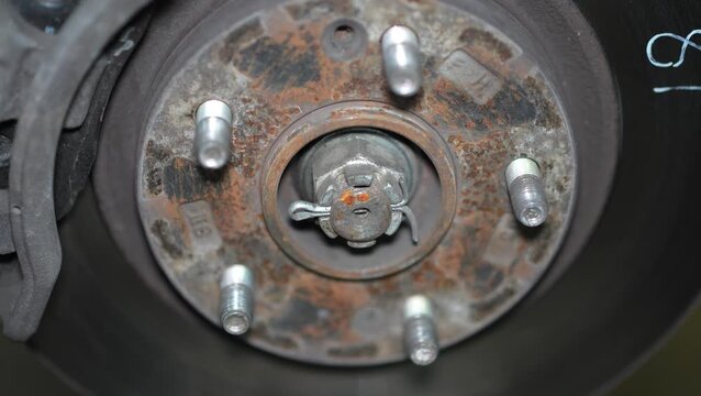 Rusty Wheel Hub Inspection in Workshop, Detailed Mechanical Maintenance, This video clip provides an intimate look into mechanical maintenance within a workshop