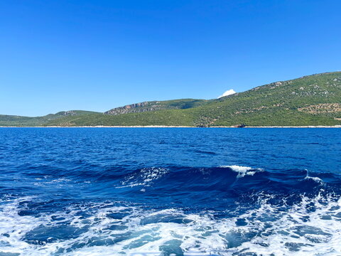 The indescribable beauty and power of the deep blue Aegean Sea, set against coastal hills barely visible on the horizon.