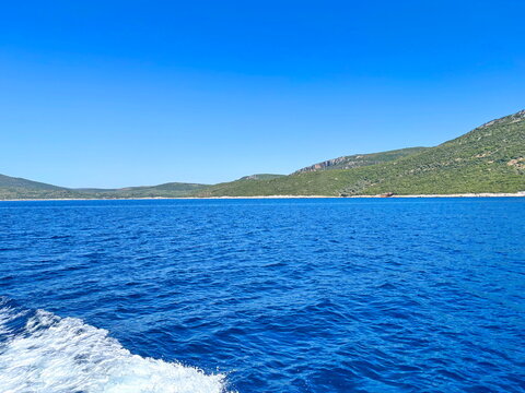 The indescribable beauty and power of the deep blue Aegean Sea, set against coastal hills barely visible on the horizon.