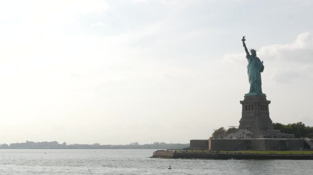Statue of Liberty on Liberty Island, New York, United States. Cooper monument, symbol of democracy and patriotism near Manhattan, NYC USA. View from ferry boat, tourist cruise.
