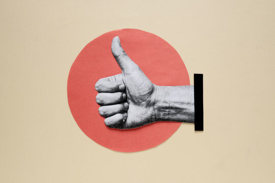 Hand showing thumbs up gesture on paper cutout red circle background