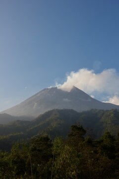 Merapi Volcano with Volcanic Steam Above Tropical Forest