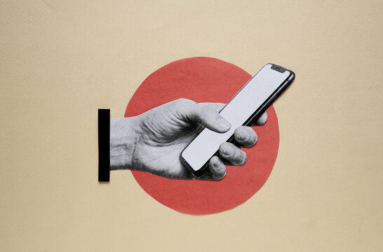 Hand holding smartphone mockup on paper cutout background with copy space