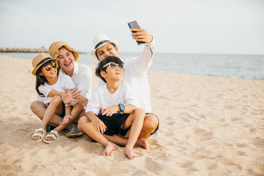 Capturing the spirit of family fun a happy family takes a cheerful selfie on the beach near the sea. Laughter smiles and the freedom of summer create a heartwarming portrait of togetherness.