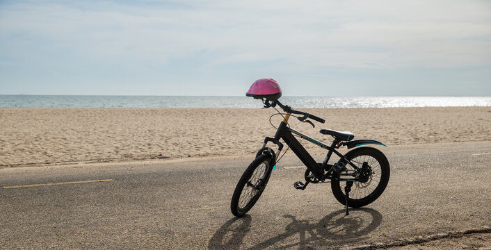 Seascape serenity, A child bicycle rests peacefully on the sandy beach creating a perfect image of leisurely tourism day in North California sun during the summer season. bike in summertime vacations