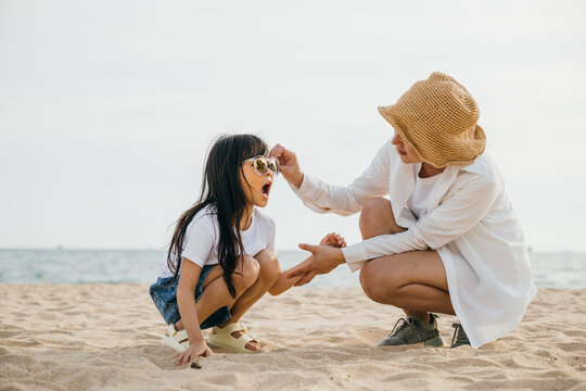Beach bliss with a loving family. Mother and daughter enjoy the sun playing in the sand. Caribbean vacation brings smiles fun and togetherness. A portrait of joy and happiness&nbsp;