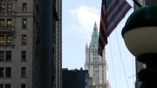 New York City Woolworth building 1913, skyscraper on Broadway in Downtown Financial District, Lower Manhattan, United States of America. Gothic historic architecture, cooper roof, USA american flag.