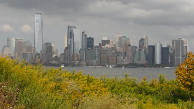 New York City Manhattan Downtown skyline from Liberty Island, United States. Financial District cityscape, World Trade Center skyscraper tower. Building architecture. Rainy cloudy autumn fall weather.