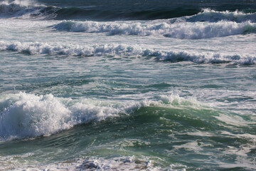 Rough ocean waves with white sea foam, close-up view of stormy turquoise water surface during a windy day. Suitable for backgrounds, travel themes, nature, or marine concepts © Alexander