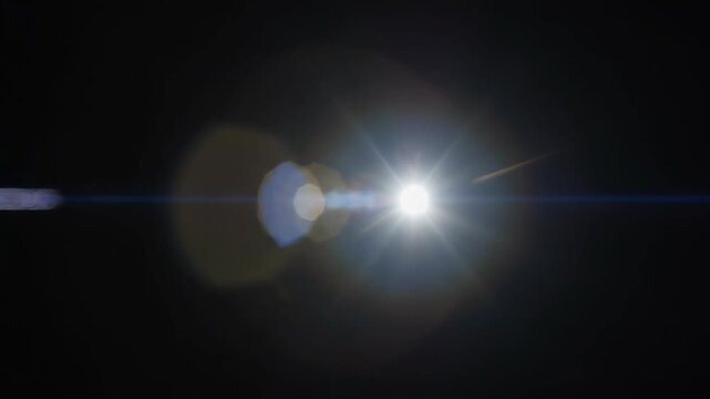Light streaks and flares emanating from a bright source during a cinematic transition against a dark background