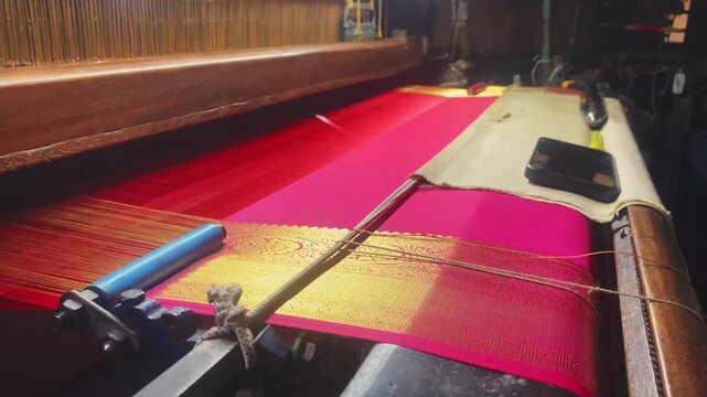 4K video of a colorful saree being woven on a power loom, showcasing the textile manufacturing process and industrial production of traditional Indian clothing.