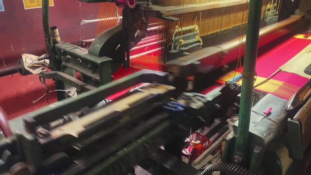 4K video of a colorful saree being woven on a power loom, showcasing the textile manufacturing process and industrial production of traditional Indian clothing.