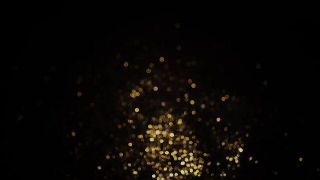 A scattering of blurred golden lights creating the effect of festive bokeh against a black background.
