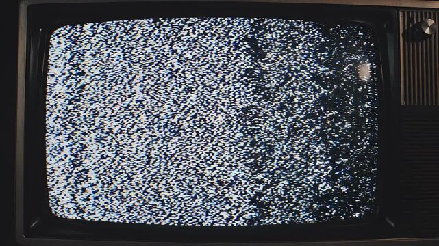 Vintage television screen displaying static and signal interference with subtle color bars during a broadcast interruption