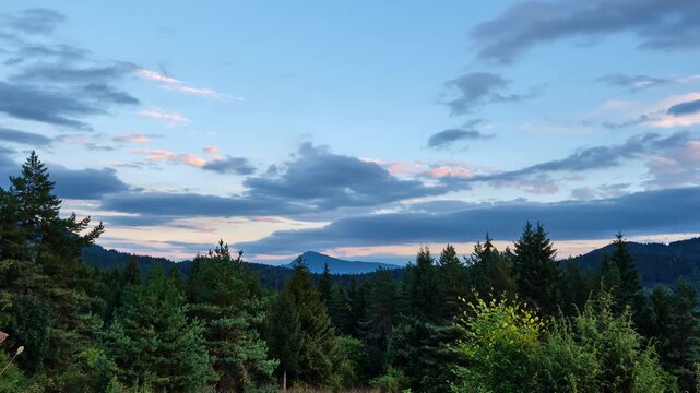 Timelapse Of Clouds Moving Over Pine Forest And Mountains At Sunset, zoom in