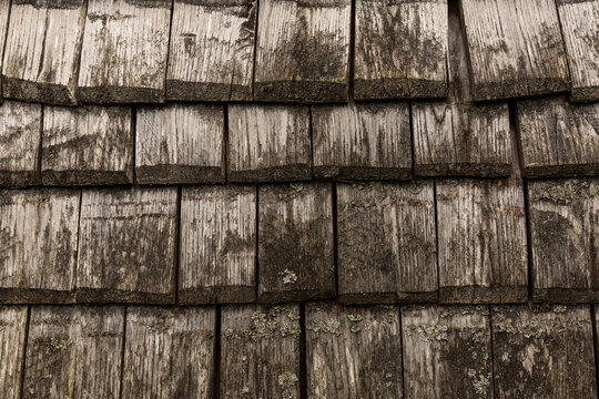 Fa&ccedil;ade en tavaillons de bois gris&eacute;s et patin&eacute;s par le temps, texture rustique et authentique, fond naturel
