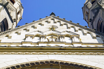 Pediment of Sacred Heart of Jesus Church in Timisoara with layered stone moldings, blind arcade, and crocket-trimmed gable. Represents Neo-Gothic verticality and monumental facade composition. © tanyatorgonskaya