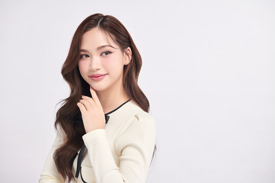 A beautiful young Asian woman with clean, fresh skin against a white background. Skincare, facial treatment, cosmetology, beauty, and spa. An elegant portrait of an Asian woman.