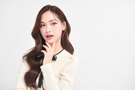 A beautiful young Asian woman with clean, fresh skin against a white background. Skincare, facial treatment, cosmetology, beauty, and spa. An elegant portrait of an Asian woman.