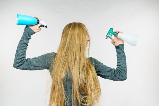 Female messy long hair holds spray bottle