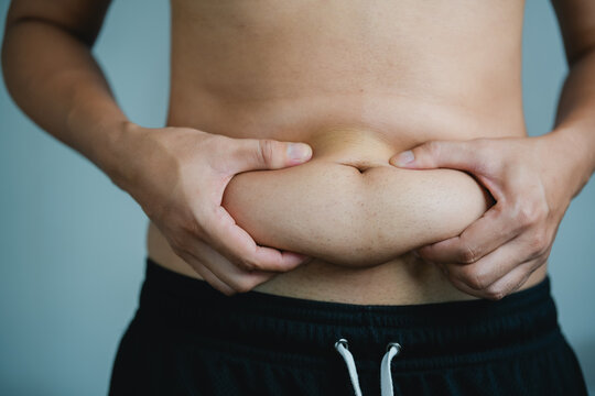 Overweight or obese man on grey background. Fat mens body measurements. he is dieting and losing weight. Healthcare, medicine concept. he is dieting and losing weight.